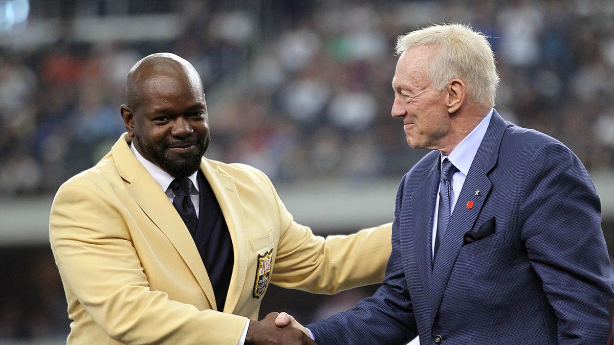 Emmitt Smith shaking hands with Jerry Jones at Cowboys Stadium