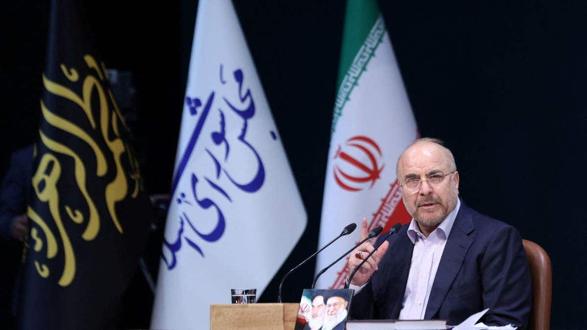 Iranian Parliament Speaker Mohammad Bagher Ghalibaf speaks during a press conference in Tehran, Iran in front of multiple flags