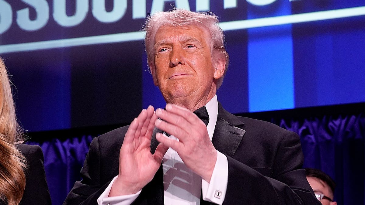 President Donald Trump standing at the White House Correspondents' Association dinner