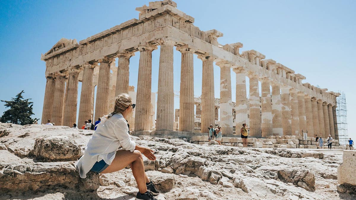 Woman relaxing while looking at Parthenon temple in Athens