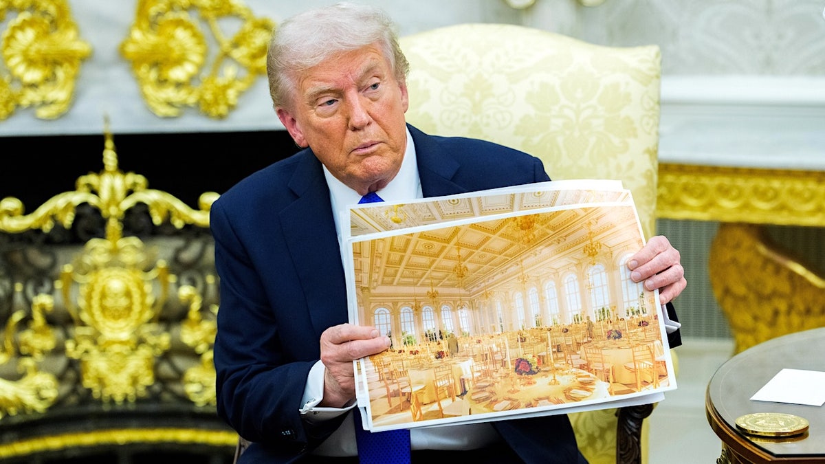 President Donald Trump holding a rendering of the White House Ballroom extension in the Oval Office