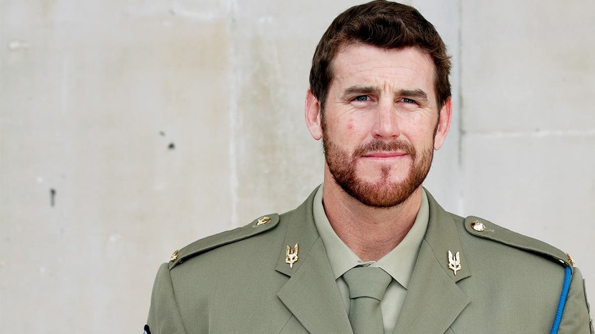 Ben Roberts-Smith standing outside St. Martin-in-the-Fields Church while wearing a suit and medals.