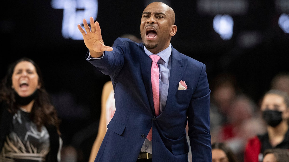 Nebraska associate head coach Chuck Love speaking to players from the sideline during a basketball game