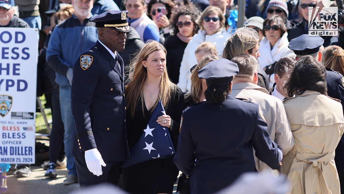 Widow Stephanie Diller standing inside Saint Rose of Lima Roman Catholic Church during funeral service