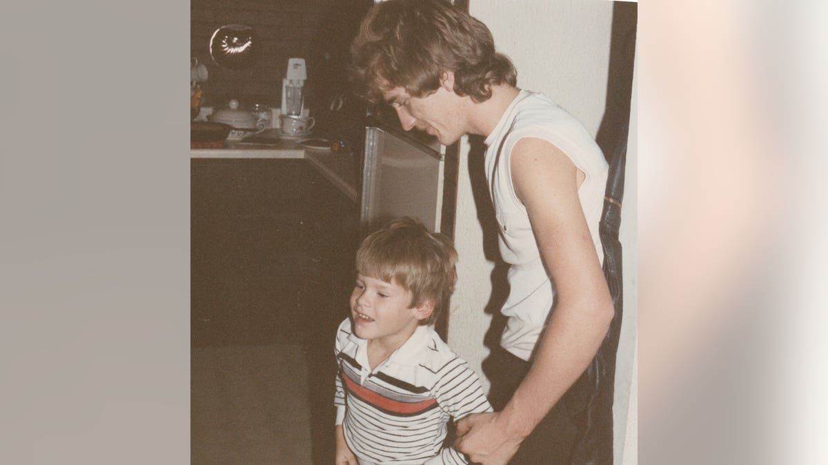 Timothy Jones Jr. being held by a young Timothy Jones Sr. in an old photographed.