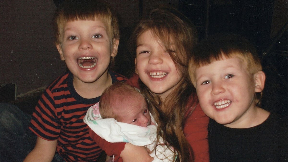 Four of Timothy Jones Jr.'s children smiling and huddling together.