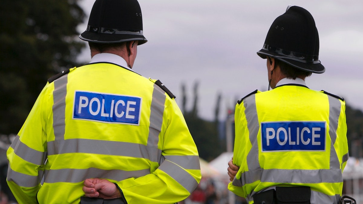 Two British Police Officers guard the entrance to the arena of a Summer Fair.