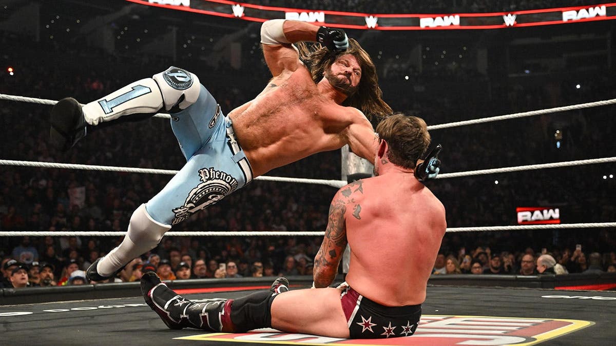 AJ Styles delivering a forearm strike to CM Punk during a wrestling match.