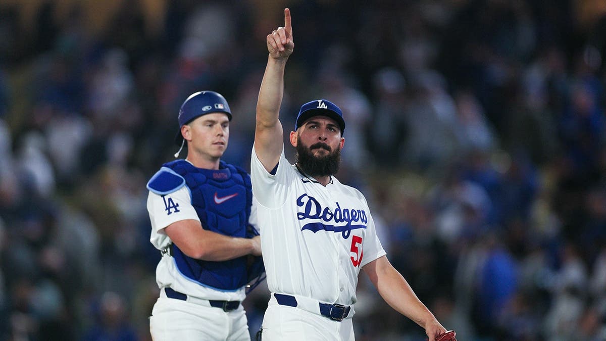 Los Angeles Dodgers pitcher Alex Vesia points towards the stands at Dodger Stadium.