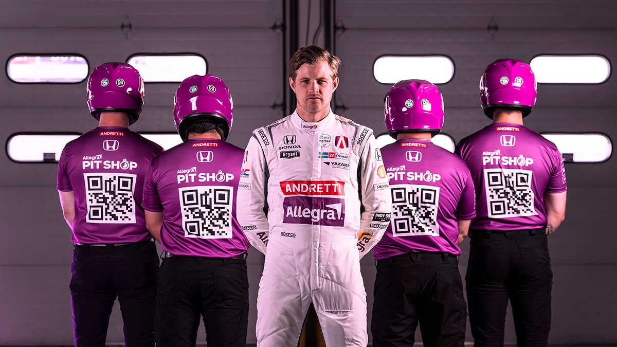 Marcus Ericsson standing with Allegra branding in the background