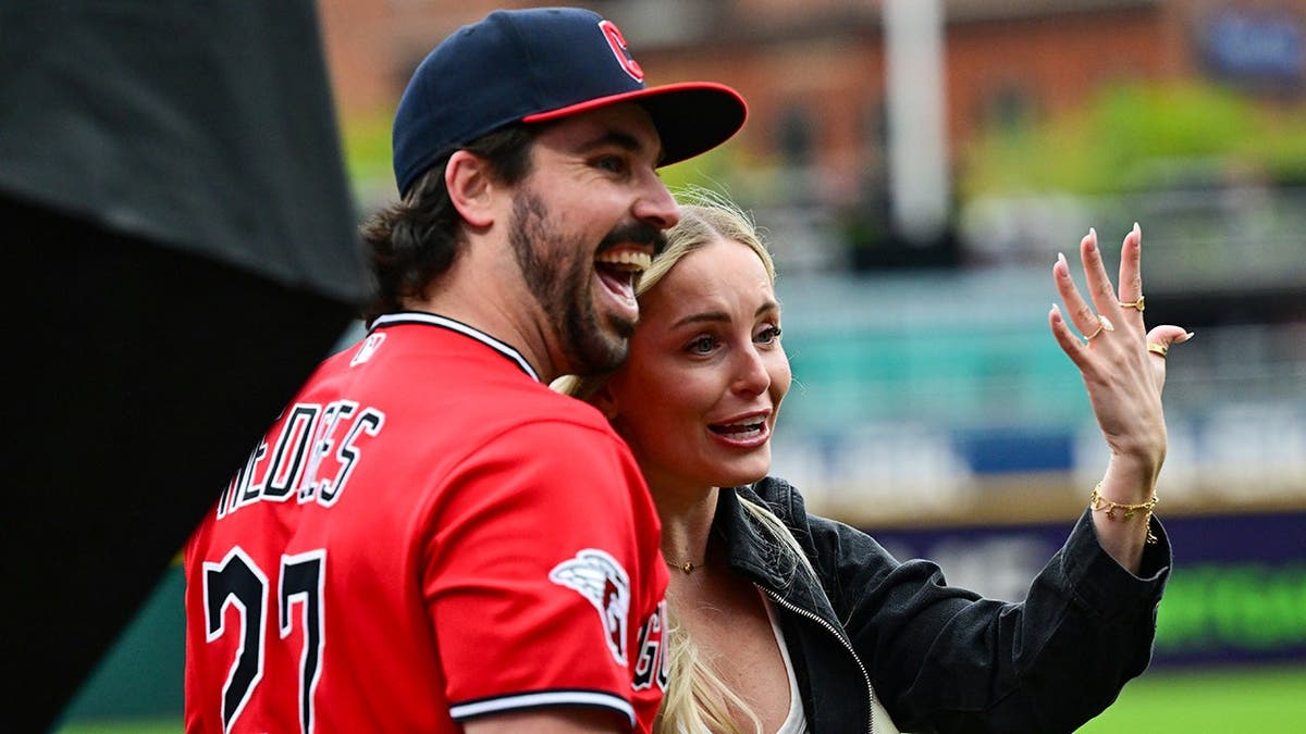 Cleveland Guardians catcher Austin Hedges and fiancée Lexi Dickinson celebrating on baseball field