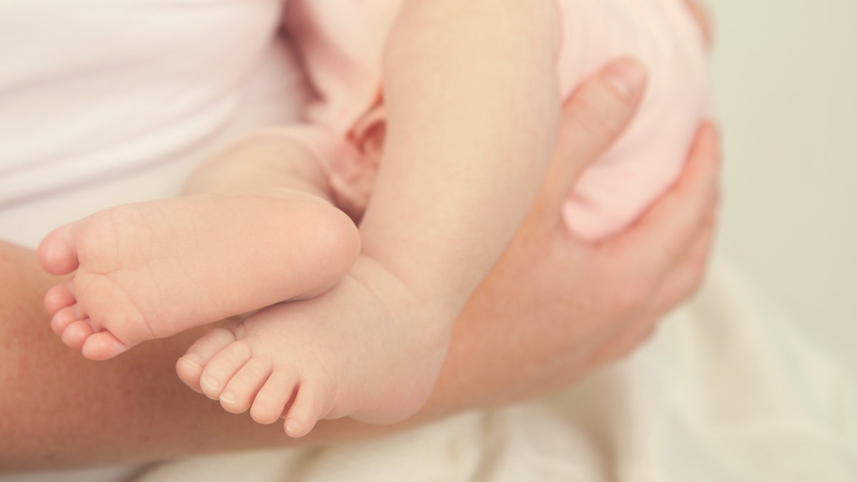 Baby Feet of baby girl being held by mother