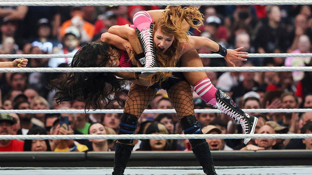 Becky Lynch withstanding AJ Lee during wrestling match at Allegiant Stadium
