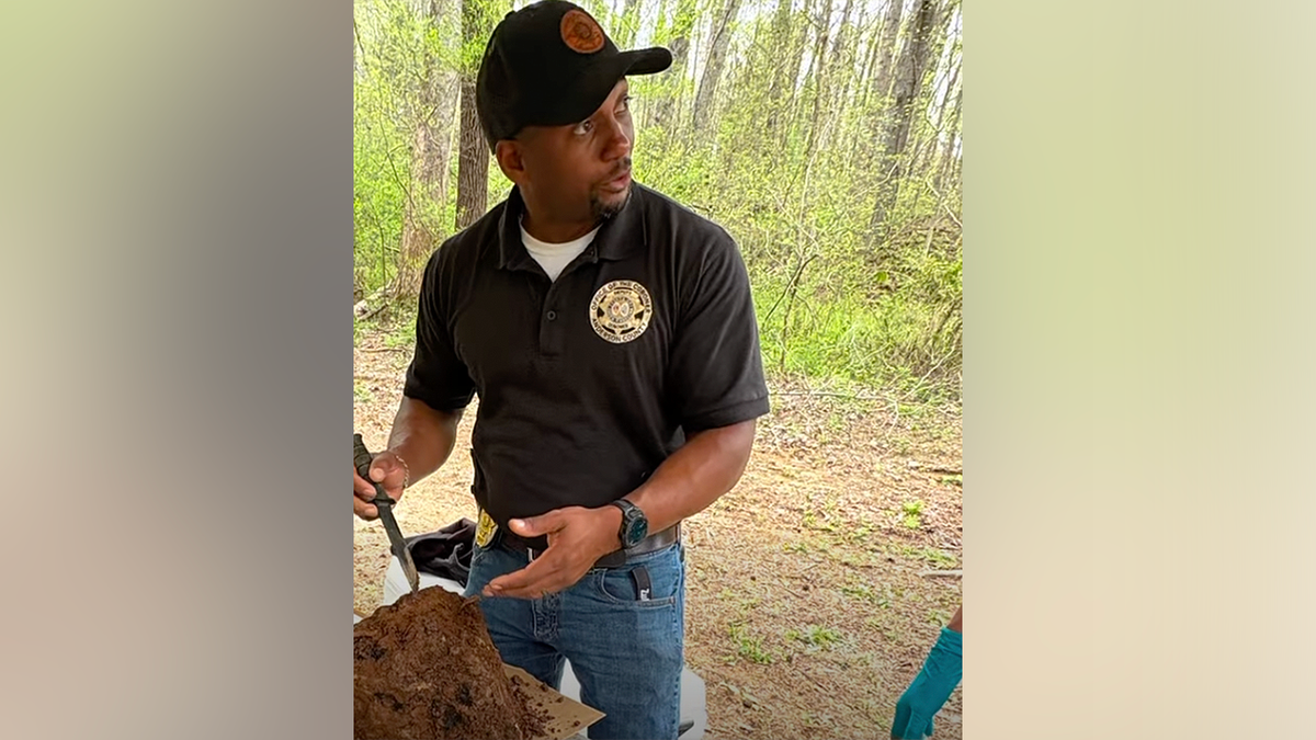 Anderson County Sheriff’s Office official examines human skull found near creek