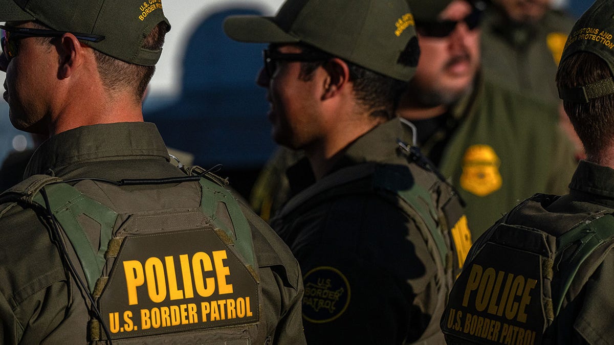 U.S. Border Patrol officers standing together at the U.S.-Mexico border in Arizona
