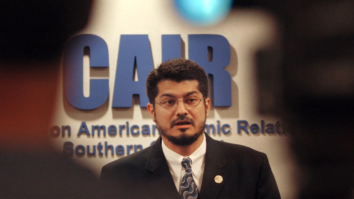 Hussam Ayloush in suit speaking