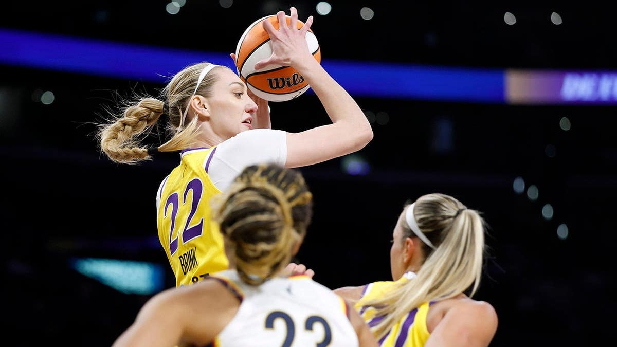 Cameron Brink of the Los Angeles Sparks controls a rebound over Aerial Powers and Julie Allemand during a basketball game.