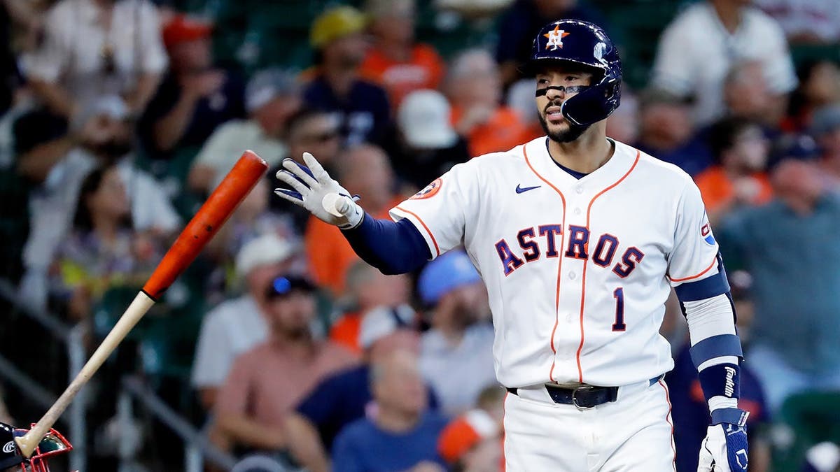 Houston Astros' Carlos Correa flips his bat rounding bases after home run.