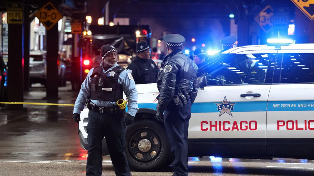 Chicago police officers stand at a crime scene in Chicago.