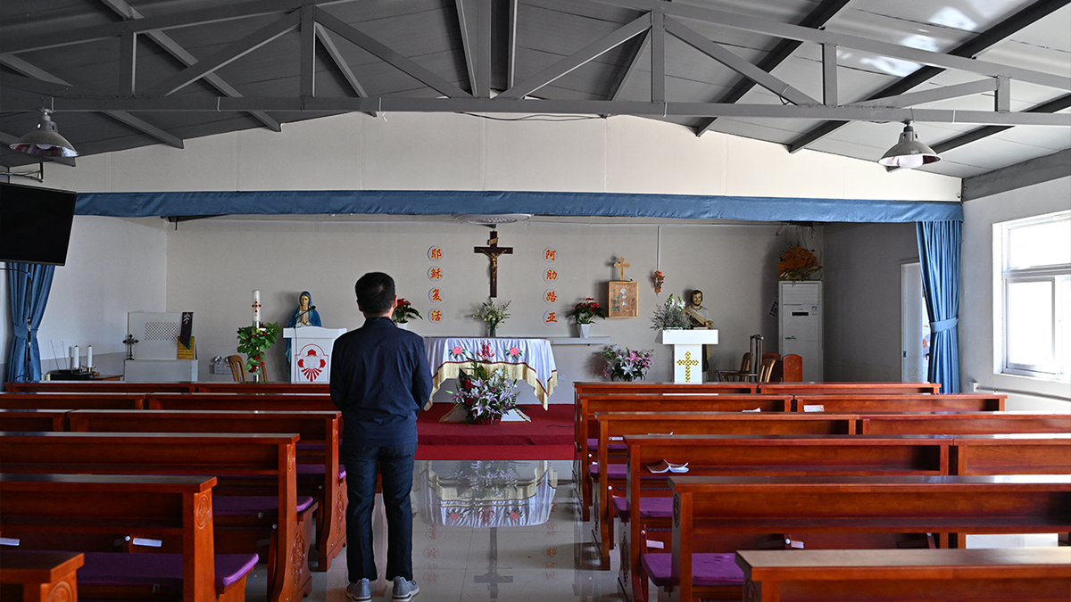 A man looking at a Catholic church in Zhuozhou, Hebei province, China