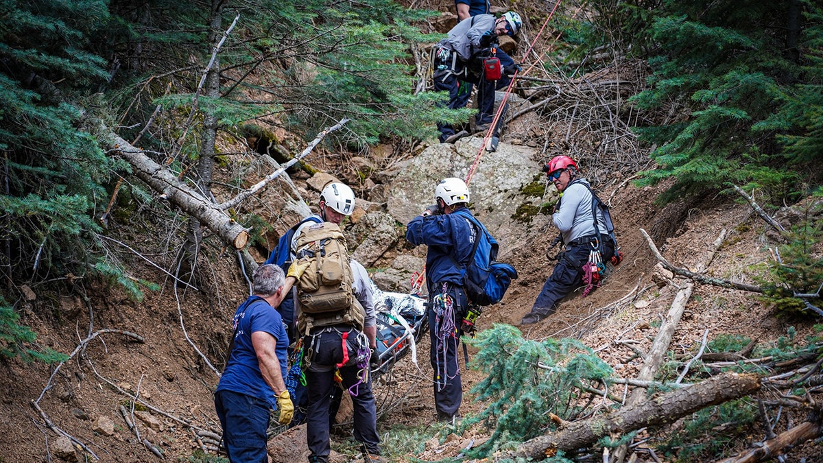 Colorado Springs Fire Department crew lowering injured climber down mountainside