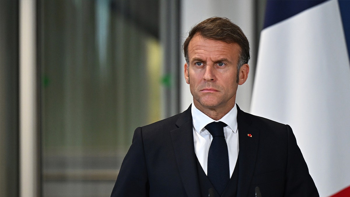 French President Emmanuel Macron standing at podium during press conference in London