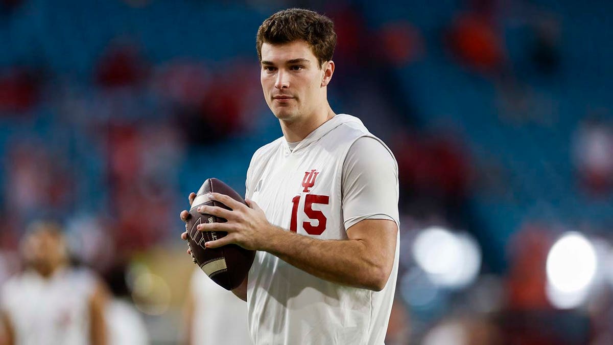 Fernando Mendoza (15) warms up before a game