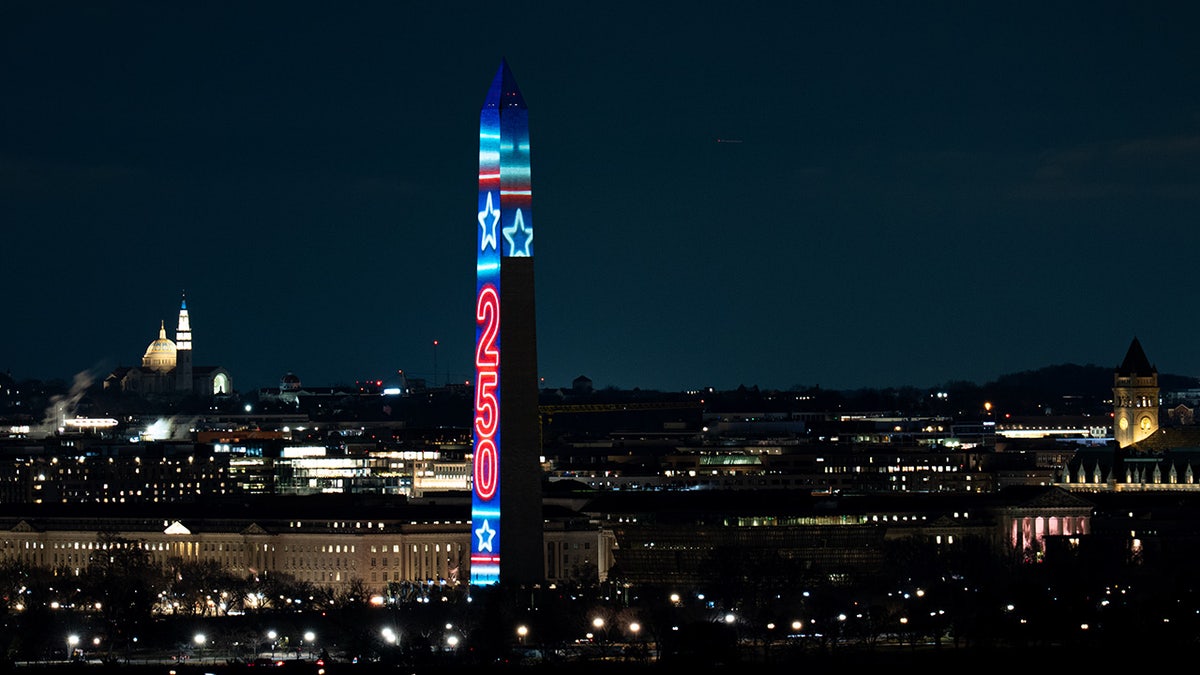 Washington Monument illuminated with Freedom 250 projection lights at night