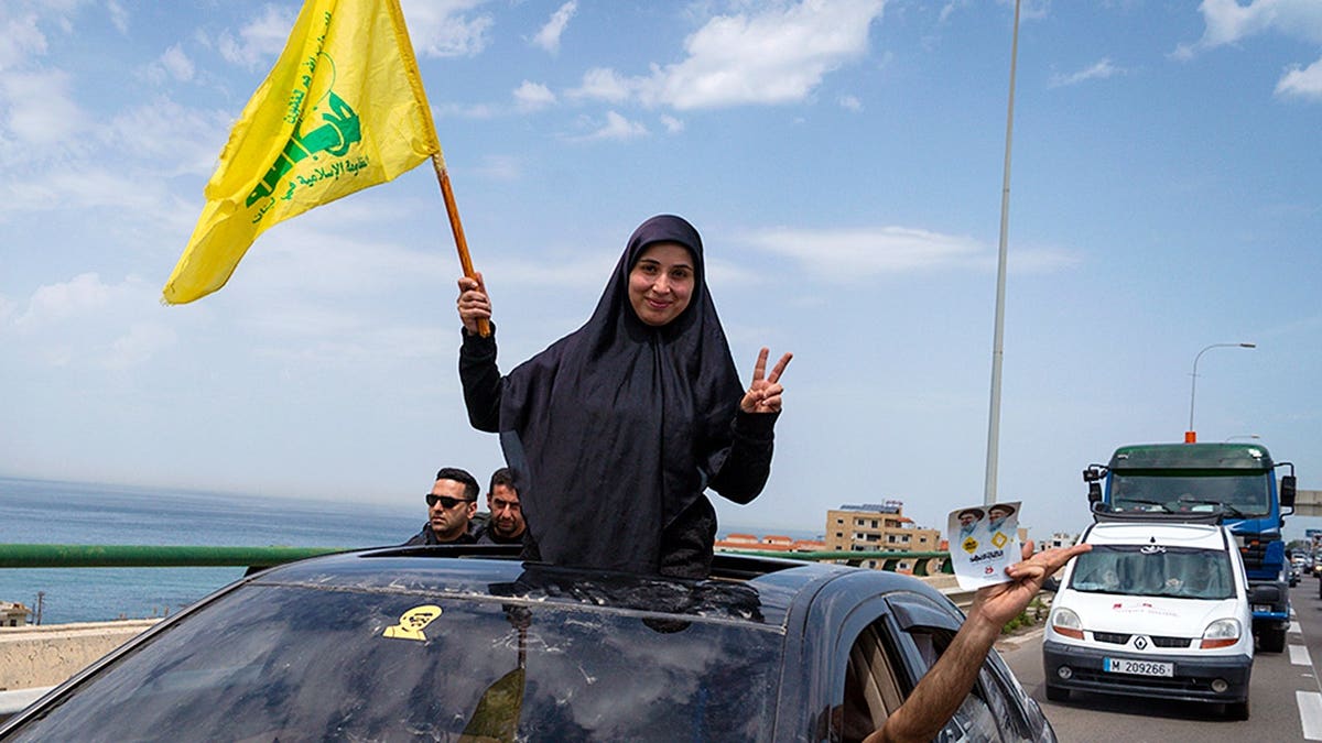 A woman waves a Hezbollah flag north of Saida in Rmeileh Lebanon