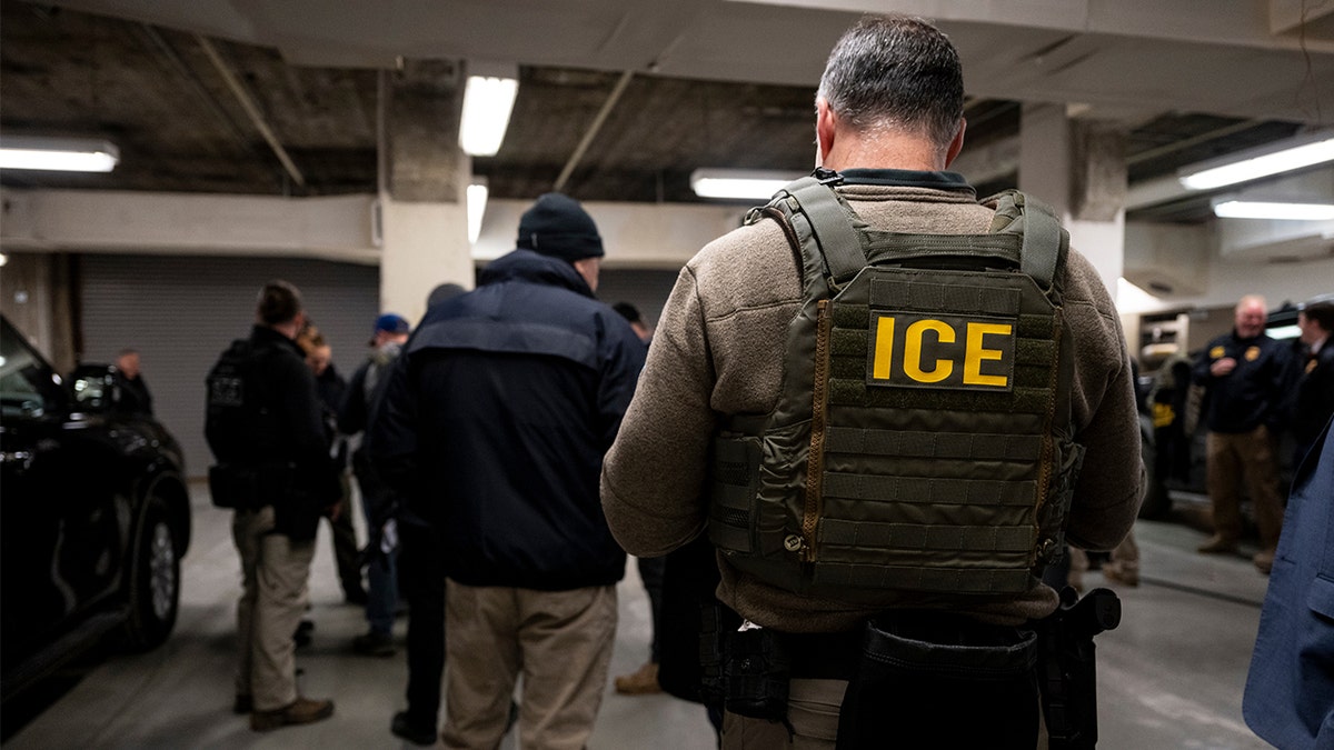ICE agents and federal law enforcement officers attending a meeting in a garage.
