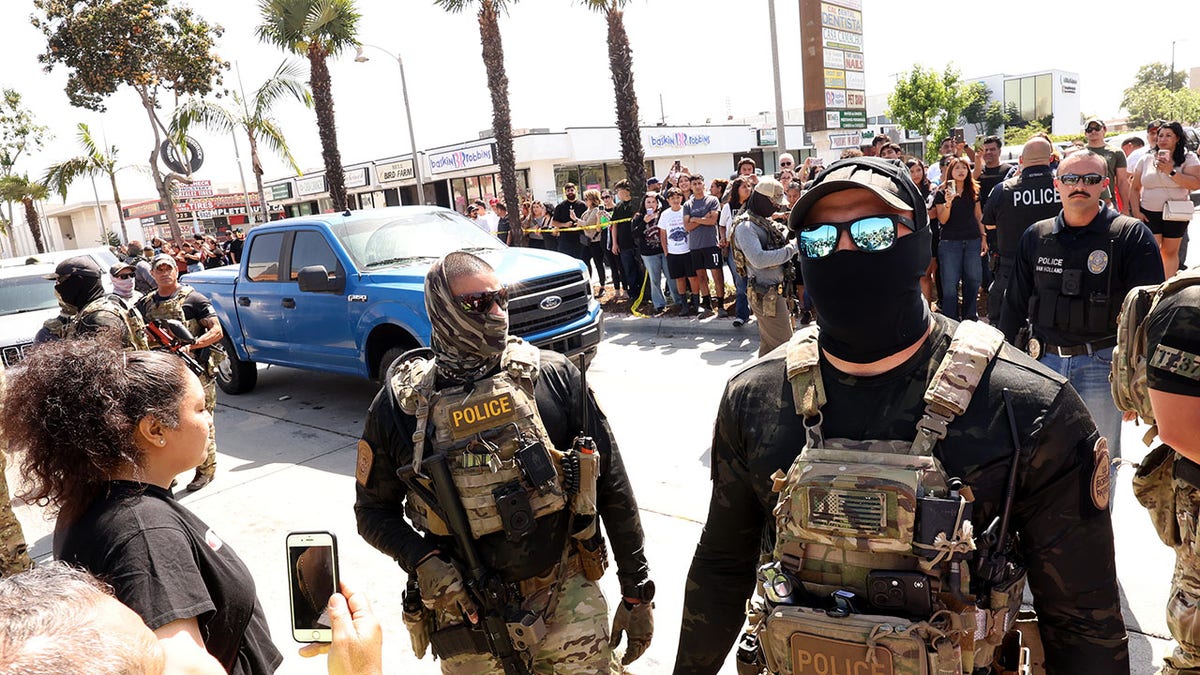Residents confronting masked federal and Border Patrol agents on Atlantic Boulevard in Bell, California
