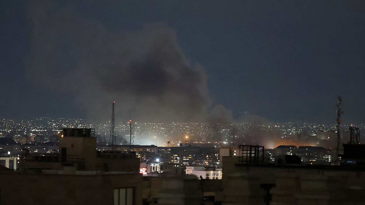 A plume of smoke rising from a strike site in Tehran