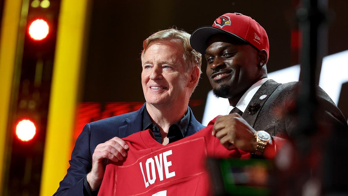 Jeremiyah Love posing with NFL Commissioner Roger Goodell at the NFL Draft in Pittsburgh