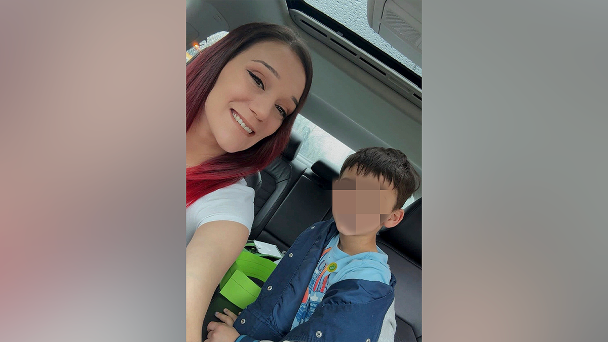 Jessica Hilliard smiles in a car selfie with her son