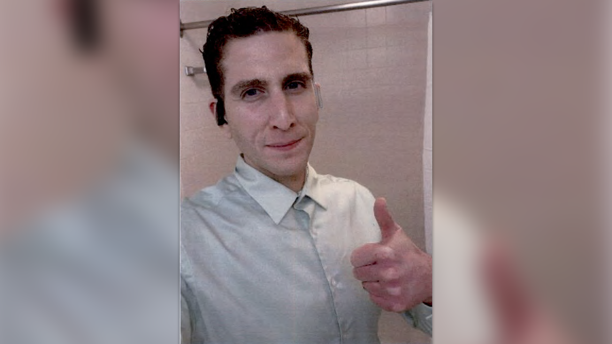 Bryan Kohberger giving a thumbs up in a selfie photo wearing a buttoned shirt and earbugs.