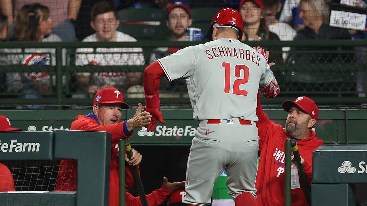 Kyle Schwarber high fiving manager Rob Thomson at Wrigley Field