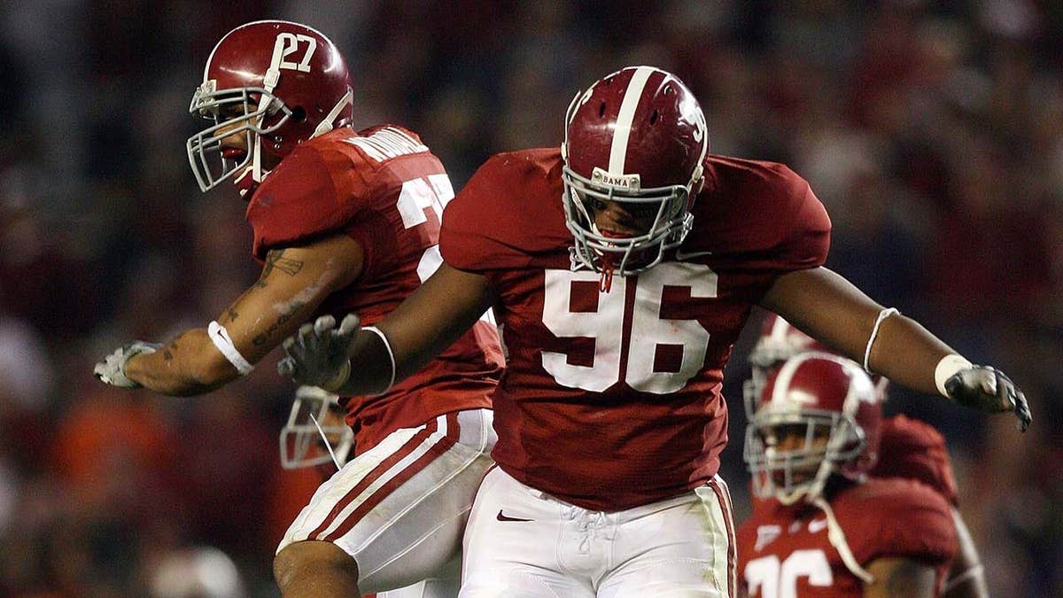 Defensive lineman Luther Davis and defensive back Justin Woodall celebrating on football field