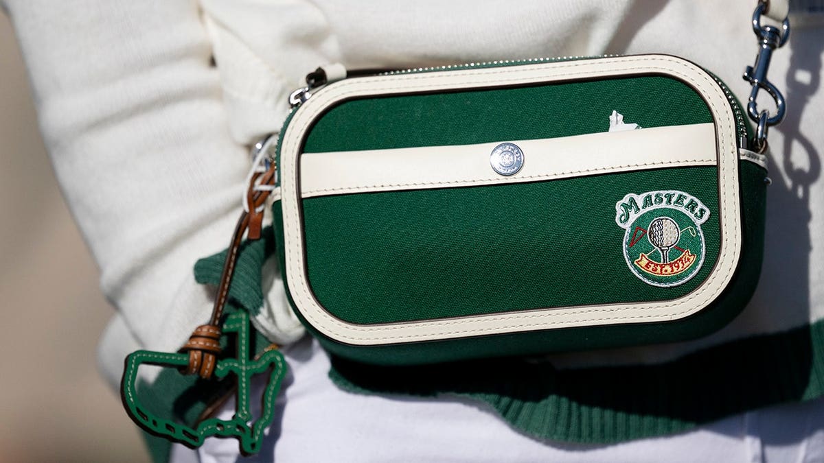 A patron holding a purse at Augusta National Golf Club during the Masters golf tournament.