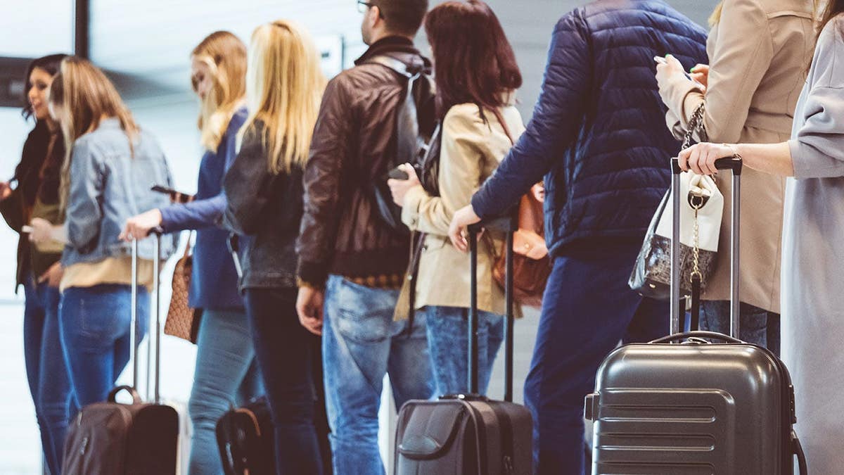 Passengers standing in a queue at an airport boarding gate