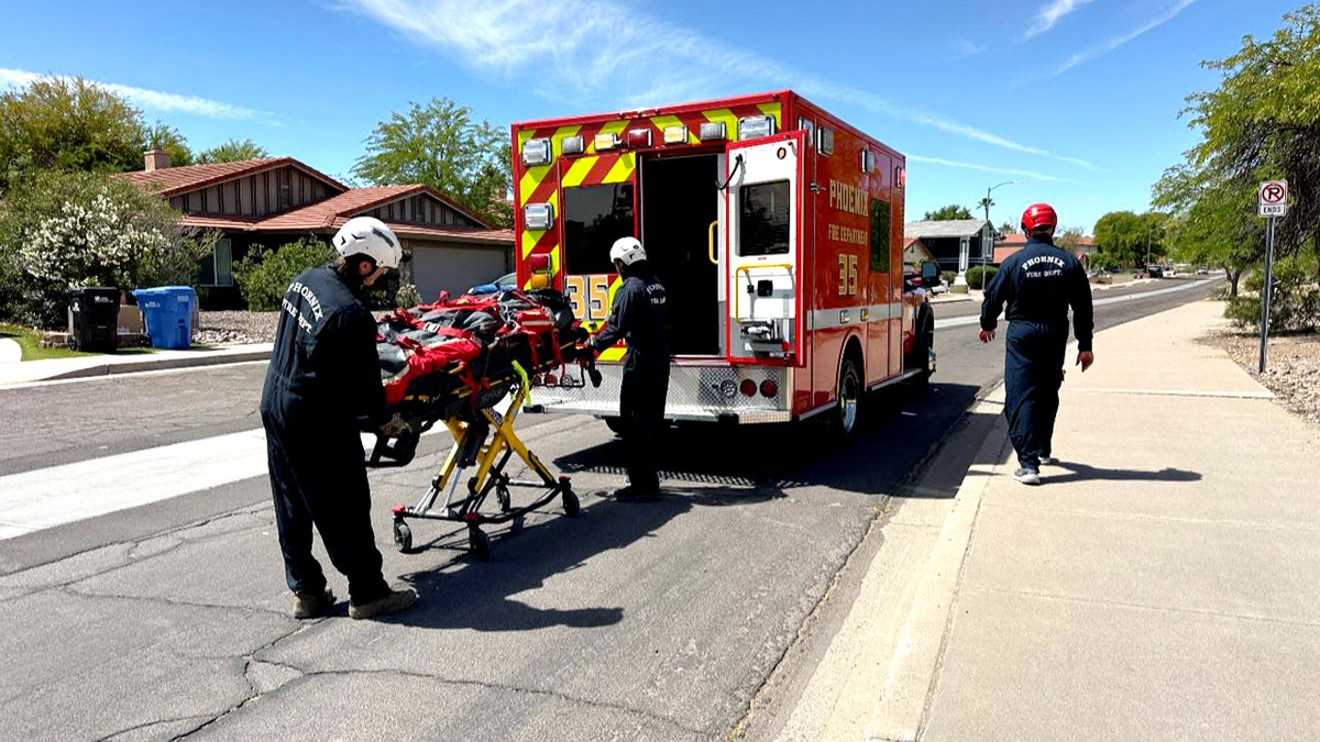 Paramedics helping a man on a gurney into an ambulance