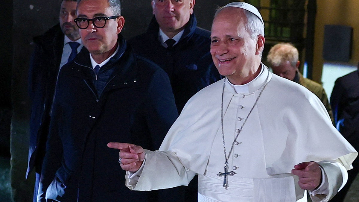 Pope Leo XIV gesturing while walking outside the papal residence in Castel Gandolfo