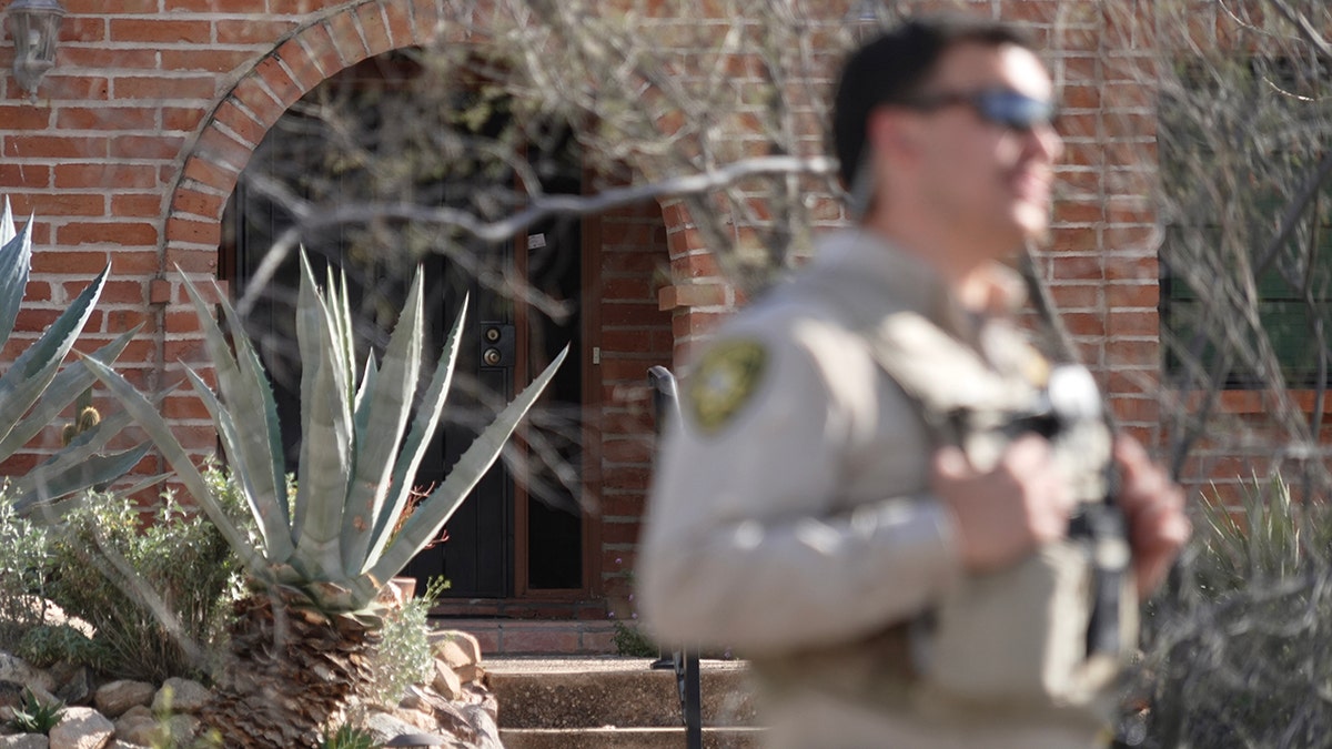 A Pima County Sheriff's Department member standing in front of Nancy Guthrie's house in Tucson