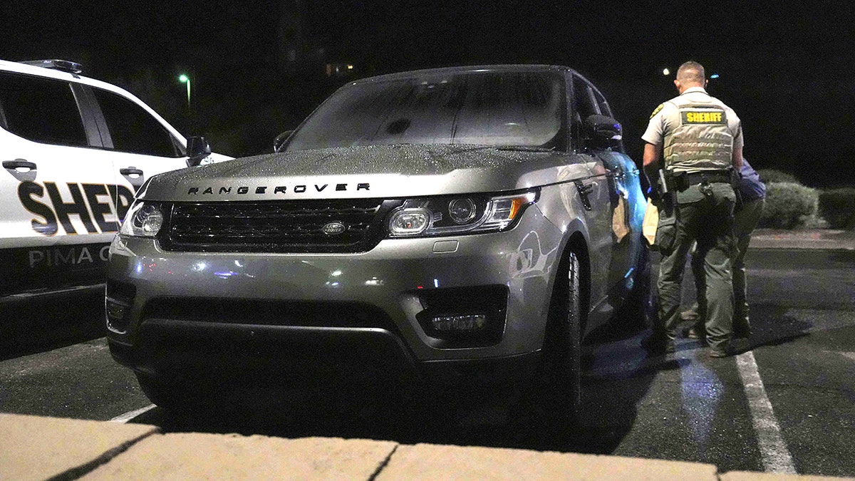 Pima County sheriff and FBI agents examining a gray Range Rover in a Culver’s parking lot in Tucson