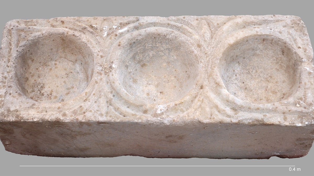 Mysterious marble object with three basins on display