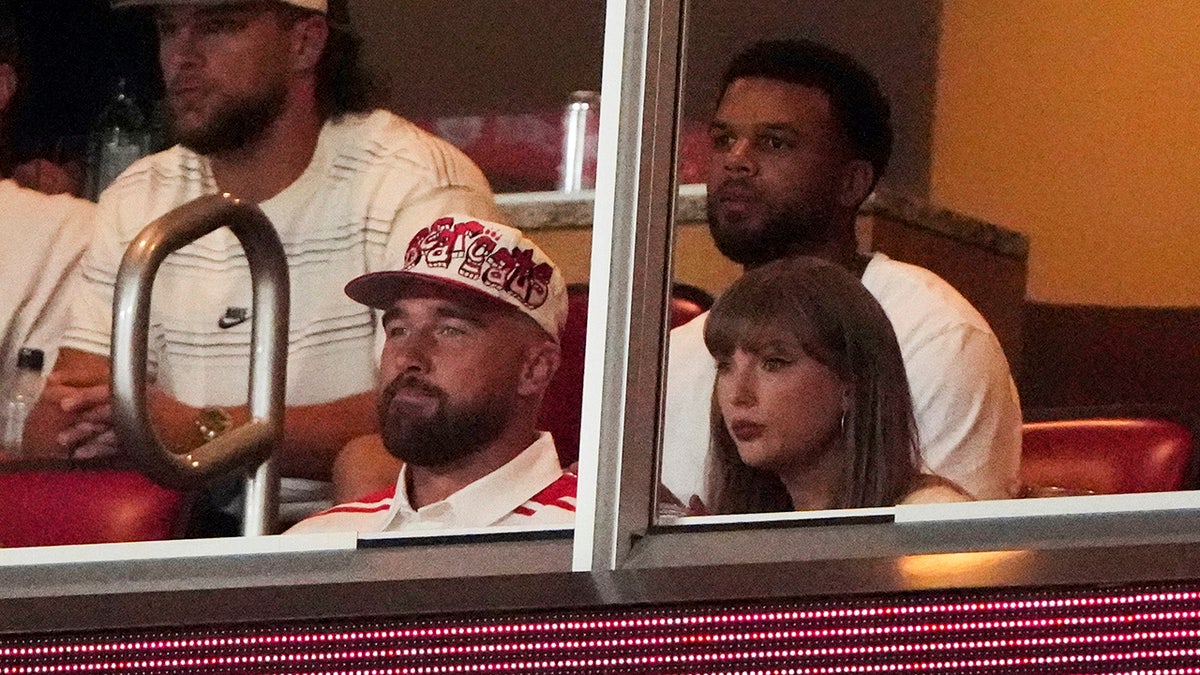 Taylor Swift sitting with fiancé Travis Kelce watching a college football game at Arrowhead Stadium