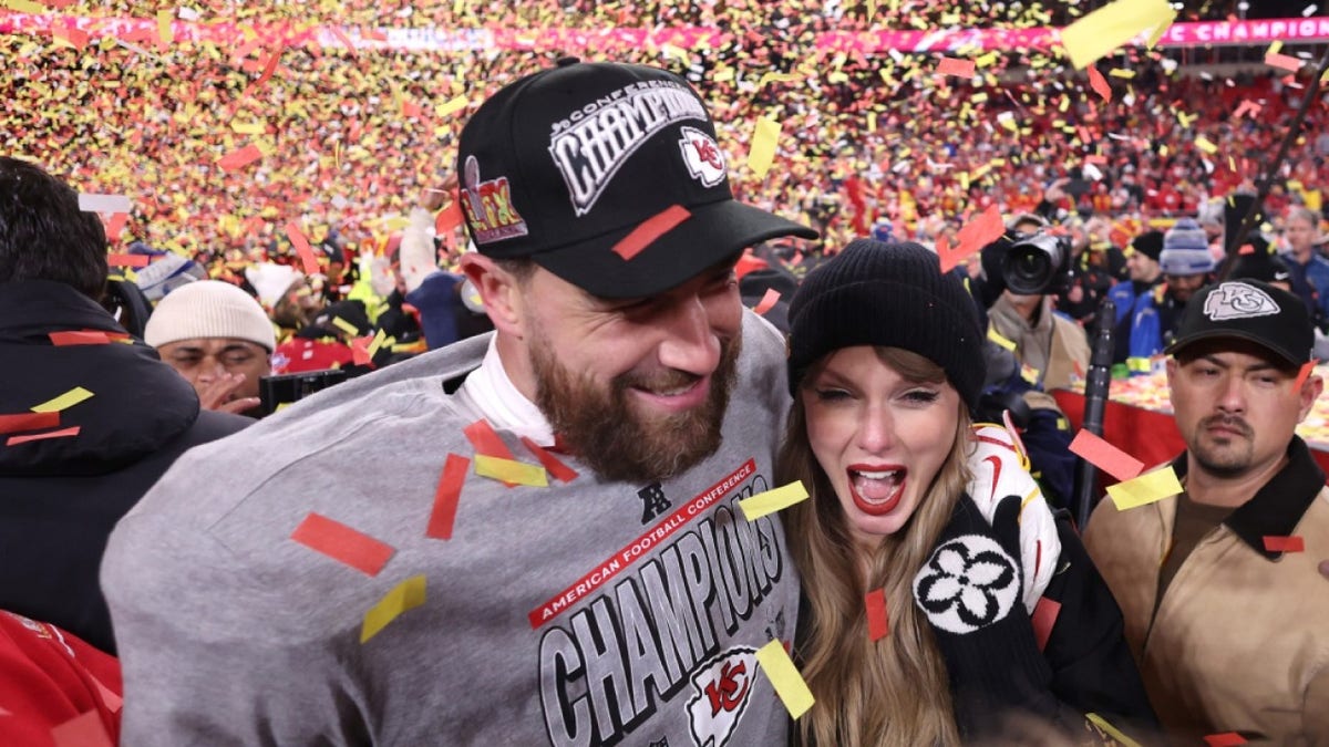 Taylor Swift and Travis Kelce embracing on a football field.