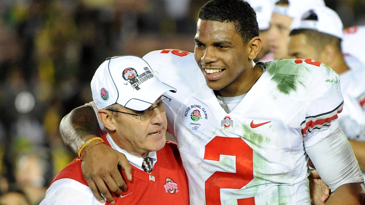 Ohio State quarterback Terrelle Pryor embraced by coach Jim Tressel and Ellen Tressel at Rose Bowl