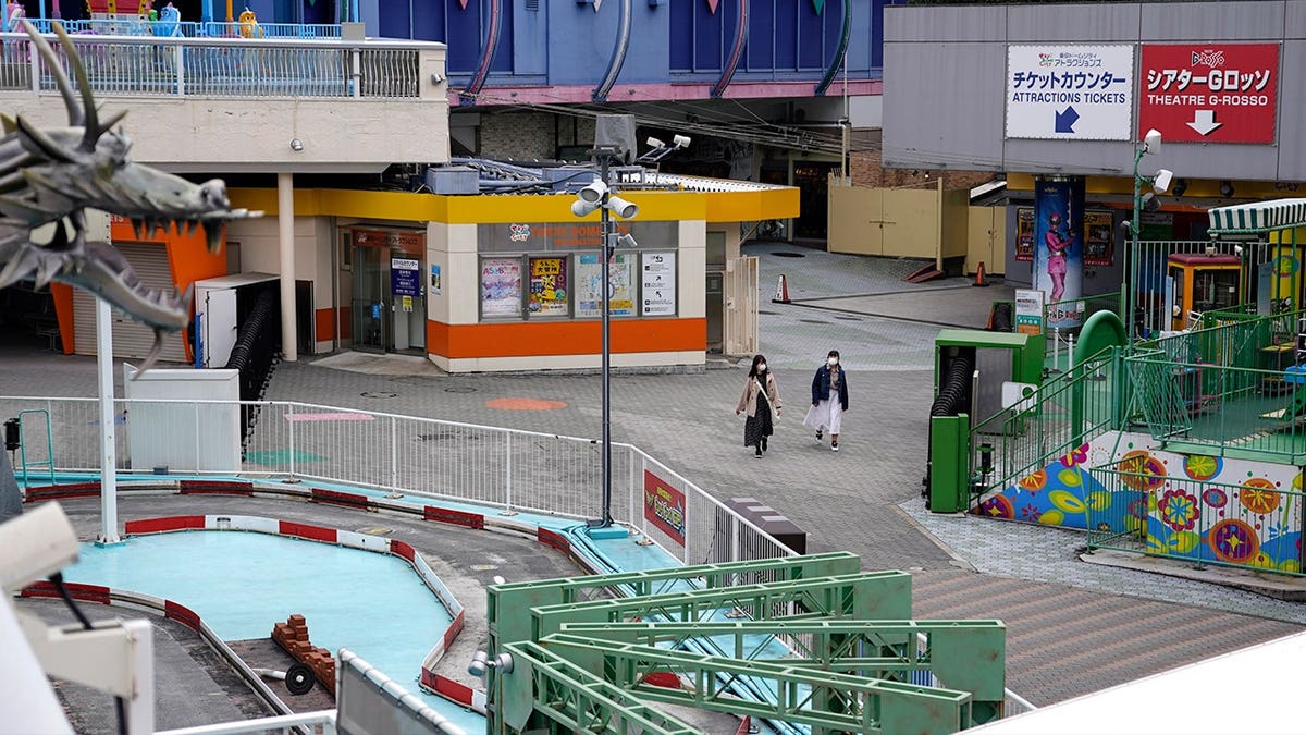 two people walk through empty theme park