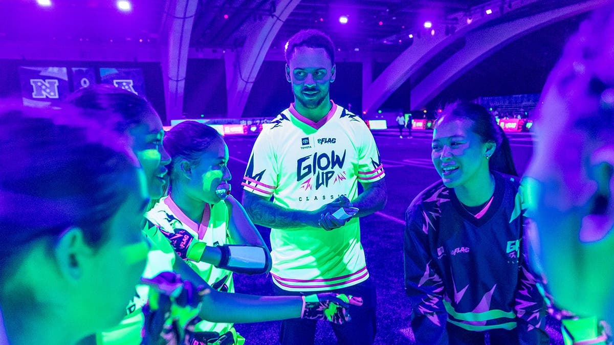 Youth players participating in glow-in-the-dark flag football at the Super Bowl Experience in San Francisco