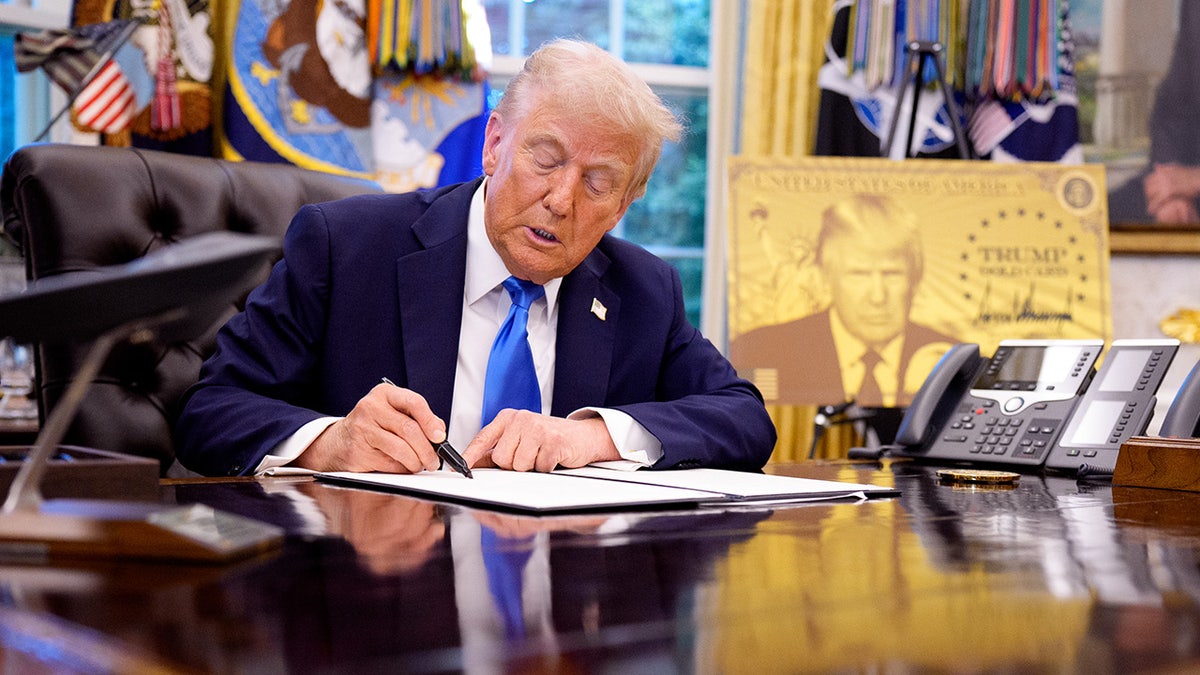 President Donald Trump signing an executive order in the Oval Office at the White House